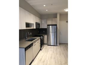 Surrey apartment for rent - A kitchen with a refrigerator, sink, and cabinets.