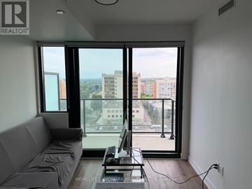 Mississauga (Cooksville) condo for rent - A living room with a grey sofa and a table with a laptop on it.