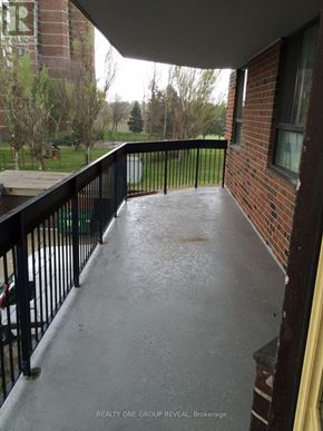 Toronto (Elms-Old Rexdale) condo for rent - A balcony with a black railing and a view of a grassy area.