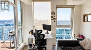Toronto (Islington-City Centre West) condo for rent - A room with a desk, chair, and a window overlooking a cityscape.