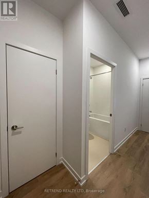 Toronto (South Riverdale) condo for rent - A hallway with a white door and a white door with a glass panel.