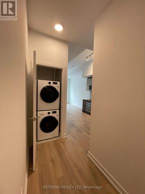 Toronto (South Riverdale) condo for rent - A hallway with a washing machine in the doorway.