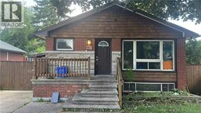 Hamilton apartment for rent - A small brown house with a black door and a small porch.