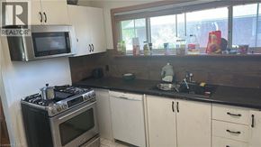 Hamilton apartment for rent - A kitchen with a stove, oven, microwave, and cabinets.