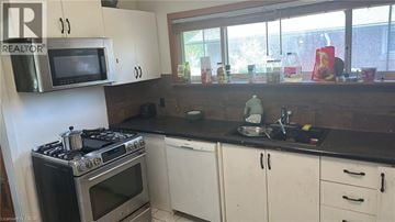 Hamilton apartment for rent - A kitchen with a stove, oven, microwave, and cabinets.