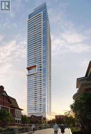 Toronto (North St. James Town) condo for rent - A tall, modern glass building stands in the foreground of a cityscape.