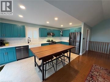 Port Dover apartment for rent - A kitchen with a wooden table and blue cabinets.
