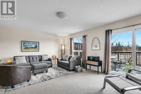 Guelph (Kortright East) townhouse for rent - A living room with a grey couch, a coffee table, and a painting on the wall.