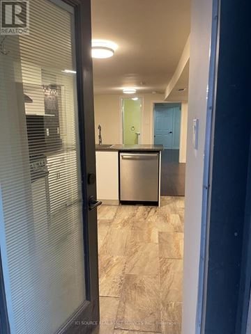 Toronto (Trinity-Bellwoods) apartment for rent - A kitchen with a stainless steel refrigerator and a wooden floor.