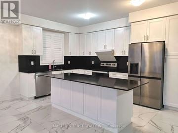 East Gwillimbury (Holland Landing) apartment for rent - A kitchen with white cabinets and black countertops.