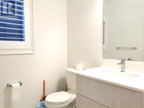 East Gwillimbury (Holland Landing) apartment for rent - A white toilet sits next to a sink in a bathroom.