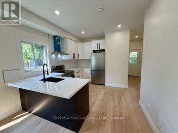 Halton Hills (Georgetown) apartment for rent - A modern kitchen with white countertops and wooden flooring.