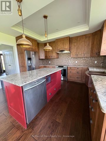 Kawartha Lakes (Fenelon) apartment for rent - A kitchen with wooden cabinets and a granite countertop.
