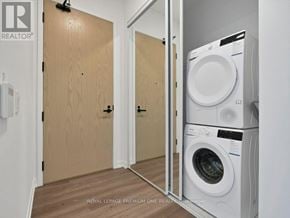 Vaughan (Vaughan Corporate Centre) condo for rent - A laundry room with a washer and dryer stacked on top of each other.