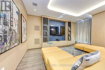 Milton (Cb Cobban) condo for rent - A modern living room with a yellow sofa and a large painting on the wall.