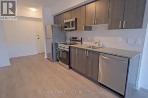 Toronto (Yorkdale-Glen Park) condo for rent - A kitchen with stainless steel appliances and wooden cabinets.