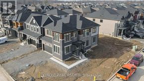 Thorold (Hurricane/Merrittville) apartment for rent - A large, modern house with a grey roof and multiple windows is under construction in a residential area.