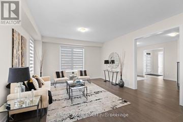 Thorold (Hurricane/Merrittville) apartment for rent - A well-lit living room with a glass coffee table and a sofa with a throw pillow.