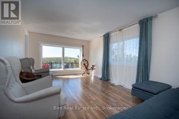 Asphodel-Norwood apartment for rent - A living room with a white couch and a window with curtains.