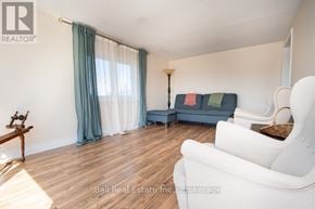 Asphodel-Norwood apartment for rent - A living room with a white sofa, a wooden table, and a lamp.