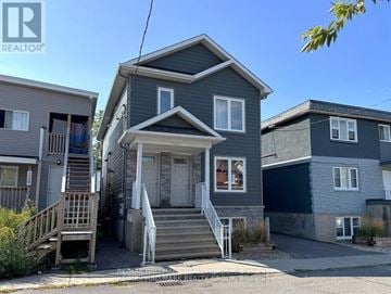 Ottawa triplex for rent - A house with a grey front yard and a sign that says REALTOR.