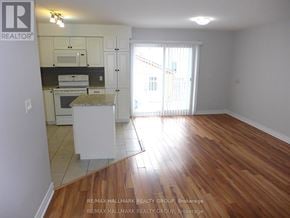Ottawa triplex for rent - A kitchen with white cabinets and a wooden floor.