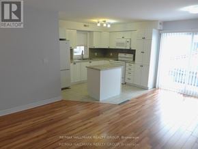 Ottawa triplex for rent - A kitchen with white cabinets and a wooden floor.