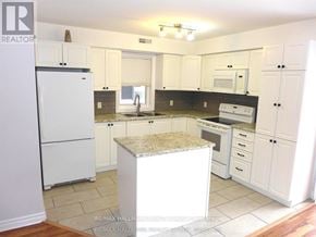 Ottawa triplex for rent - A kitchen with white appliances and cabinets.