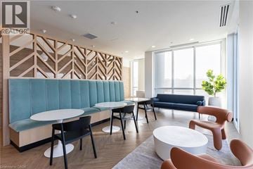 Kitchener condo for rent - A modern living room with a blue sofa and wooden accents.