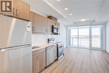Kitchener condo for rent - A well-lit kitchen with wooden cabinets and a refrigerator.