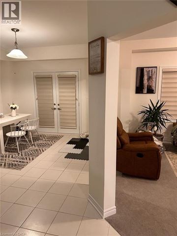 Paris apartment for rent - A living room with a brown chair and a plant.