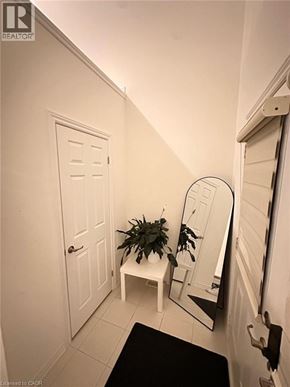 Paris apartment for rent - A white door with a mirror and a potted plant on a white table.