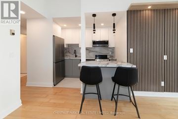 Toronto (Mount Pleasant West) condo for rent - A modern kitchen with a bar stool and a fridge.