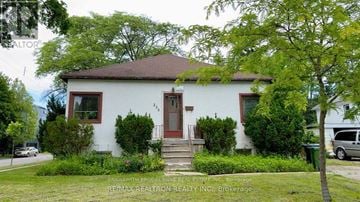 Toronto (Lansing-Westgate) apartment for rent - A white house with a brown roof and a red door.