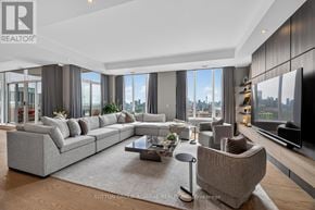 Toronto (Casa Loma) condo for rent - A modern living room with a large grey sofa and a coffee table in the center.