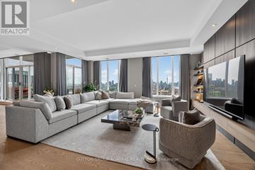 Toronto (Casa Loma) condo for rent - A modern living room with a large grey sofa and a coffee table in the center.