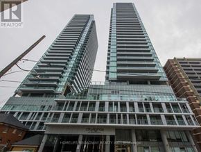 Toronto (Mount Pleasant West) condo for rent - Two tall buildings with glass windows and balconies are in front of a cloudy sky.