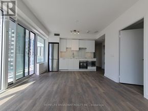 Toronto (Mount Pleasant West) condo for rent - A spacious kitchen with white cabinets and a wooden floor.