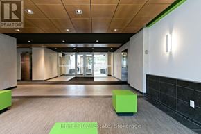 Toronto (University) condo for rent - A hallway with a green cube on the floor and a sign that says Infinite Real Estate Brokerage.