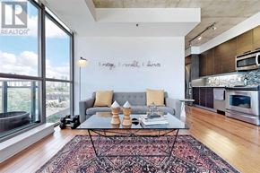 Toronto (Moss Park) condo for rent - A living room with a grey couch and a coffee table in front of a window.