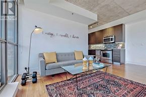 Toronto (Moss Park) condo for rent - A living room with a grey couch, a coffee table, and a rug.