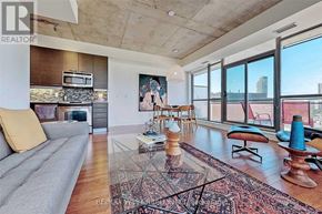 Toronto (Moss Park) condo for rent - A living room with a grey sofa and a rug in the middle.