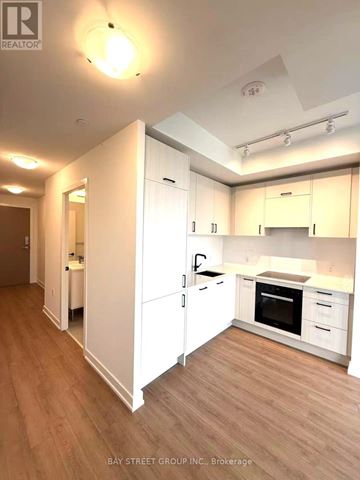 Toronto (Banbury-Don Mills) condo for rent - A kitchen with white cabinets and a wooden floor.