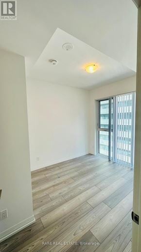 Toronto (Waterfront Communities) condo for rent - A room with a slanted ceiling and a door leading to a balcony.