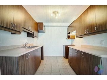Thurso condo for rent - A kitchen with brown cabinets and a white counter top.