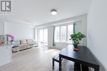 Oakville (Jm Joshua Meadows) townhouse for rent - A well-lit, spacious living room with a dining table and chairs.