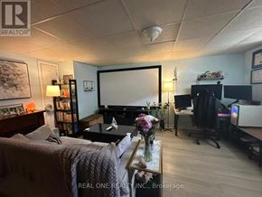 Oakville (Wo West) apartment for rent - A living room with a couch, a coffee table, a television, and a bookshelf.