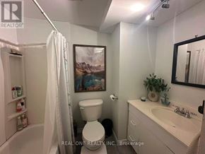 Oakville (Wo West) apartment for rent - A white bathroom with a toilet, sink, and a painting on the wall.