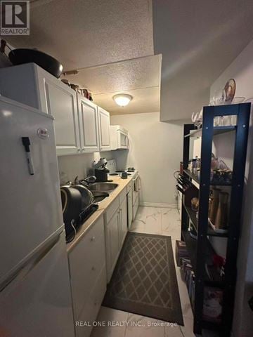 Oakville (Wo West) apartment for rent - A kitchen with white cabinets and a black stove top.