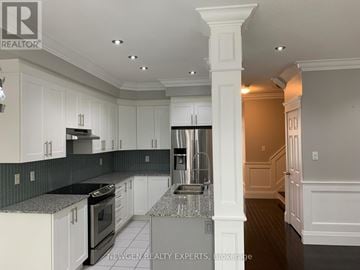 Brampton (Northwest Brampton) townhouse for rent - A kitchen with white cabinets and a black countertop.